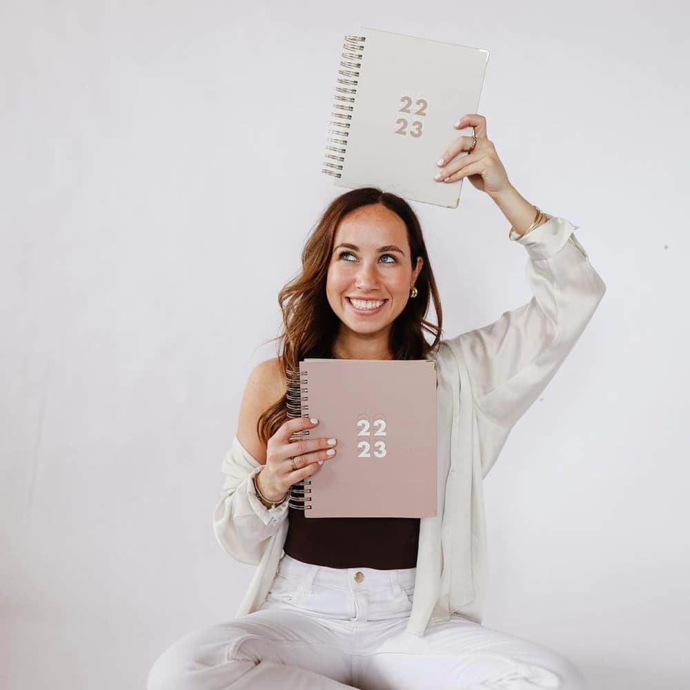 Sophia smiling, holding planners, in 2022.