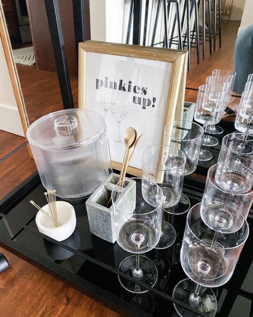 Tray with "Pinkies Up" sign and drink glasses.
