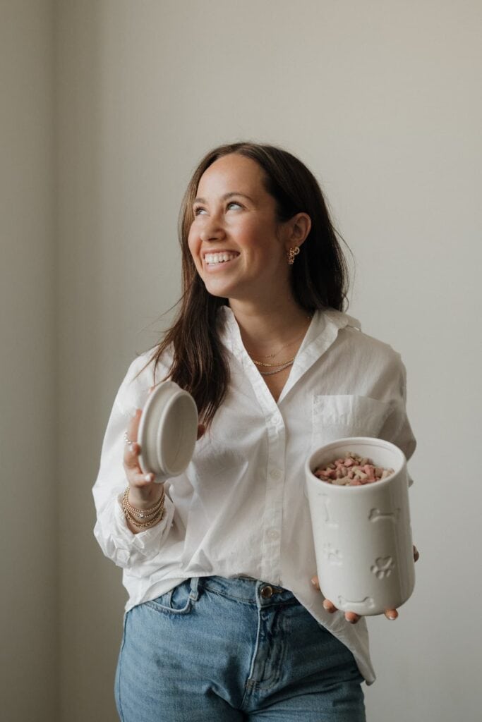 Sophia smiling, wearing a white shirt, holding treats.